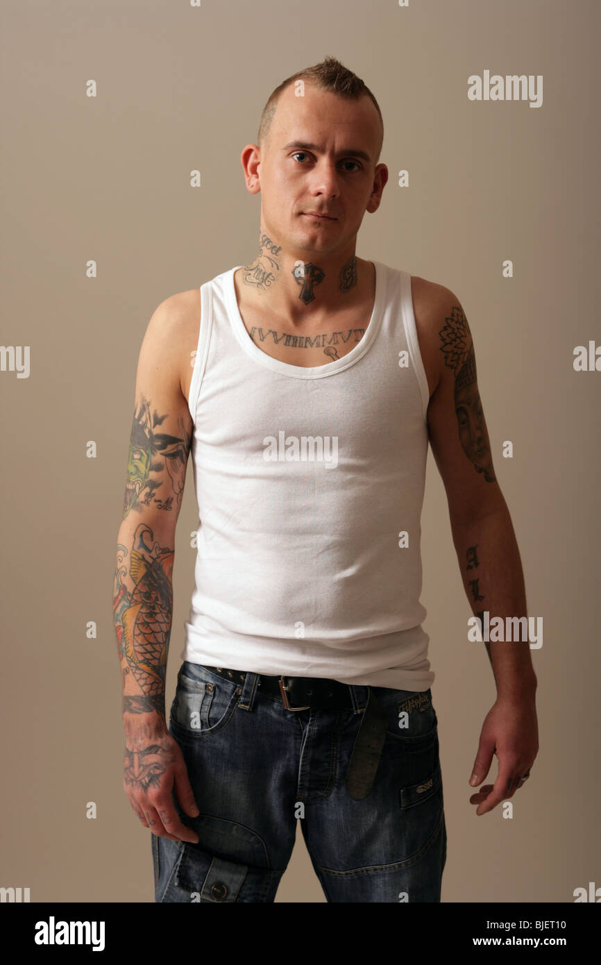 Tatuato uomo che indossa un giubbotto di bianco. Foto Stock