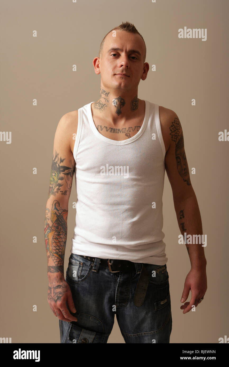 Tatuato uomo che indossa un giubbotto di bianco. Foto Stock