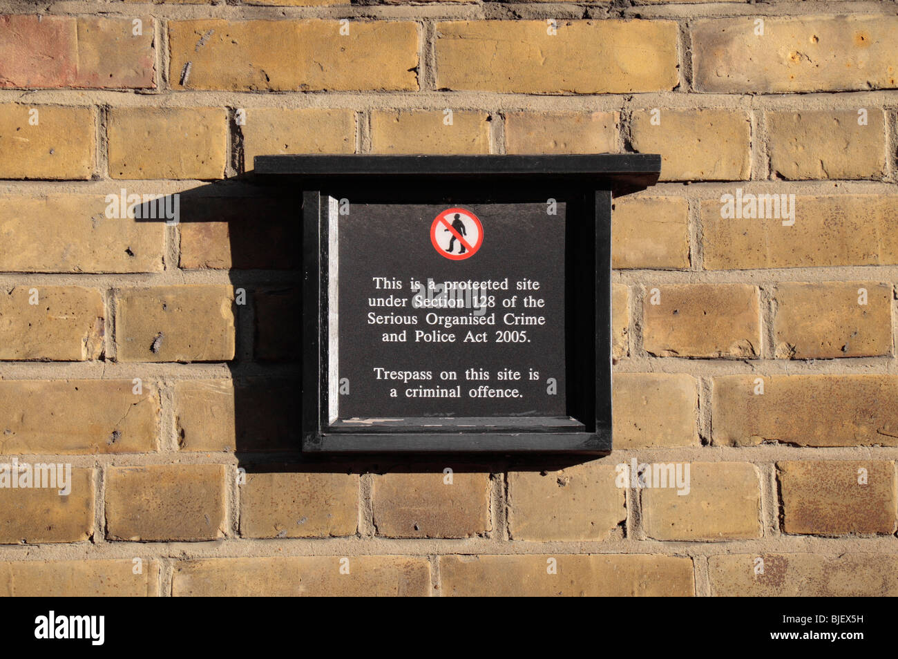 I trasgressori di un cartello di avviso sulla parete circondante il Buckingham Palace di Londra, Regno Unito. Foto Stock