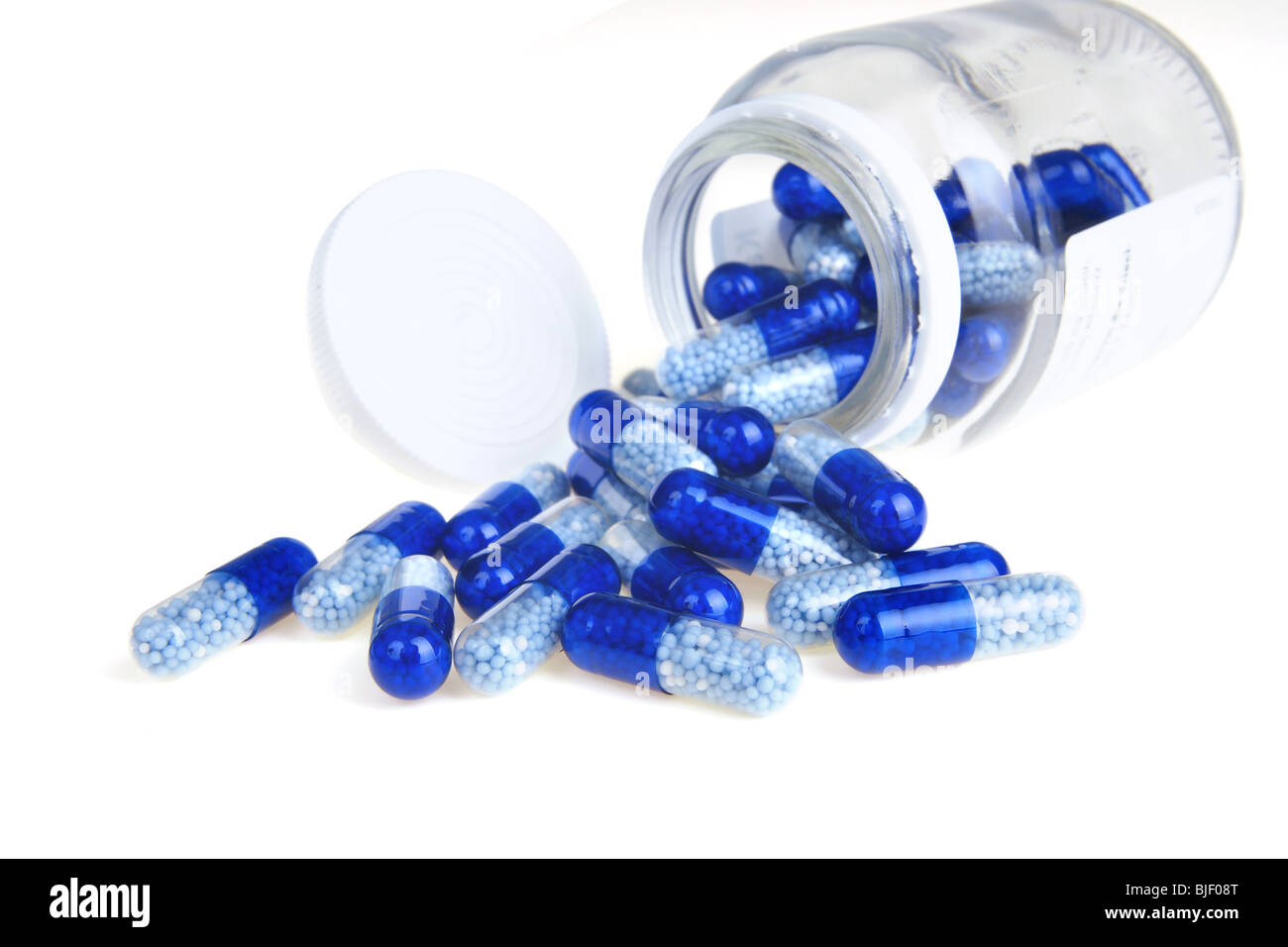 Bottiglia capovolta della capsula blu su sfondo bianco Foto Stock