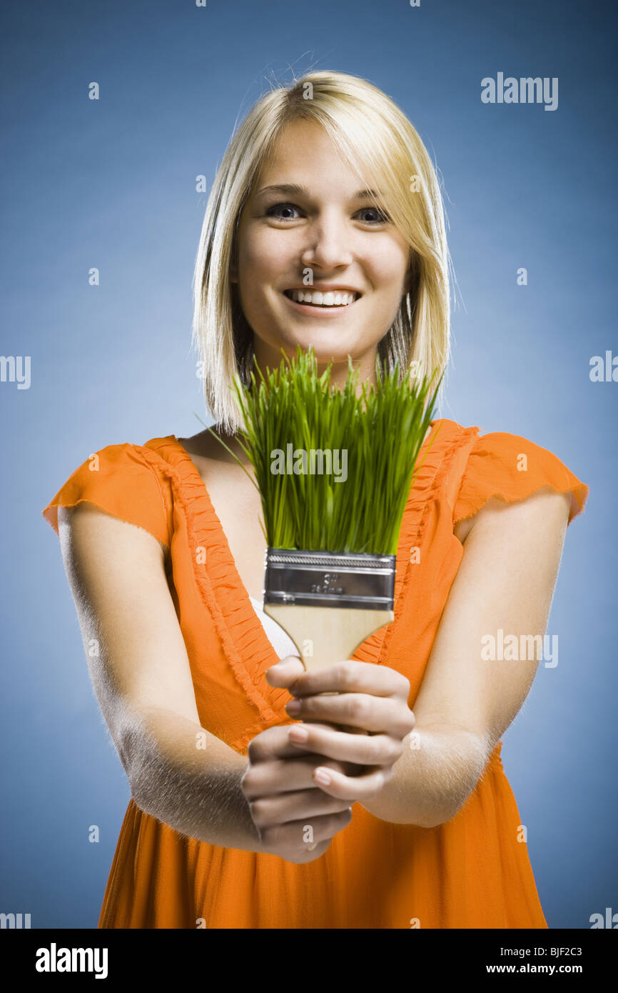 Donna che mantiene un pennello di erba Foto Stock