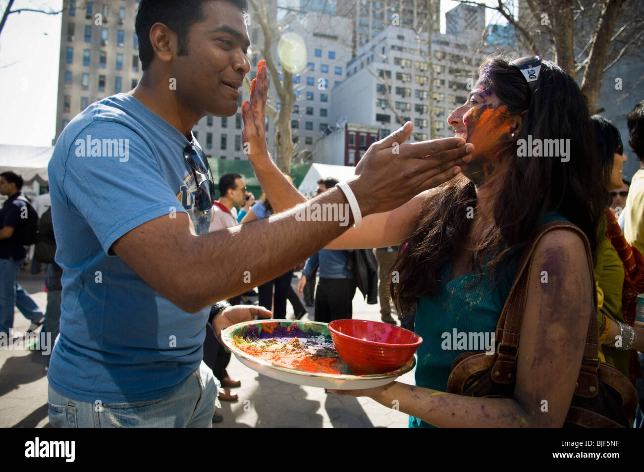 Polvere colorata viene applicata per i volti dei partecipanti come si celebra la vacanza indiano di Holi a street festival di NY Foto Stock