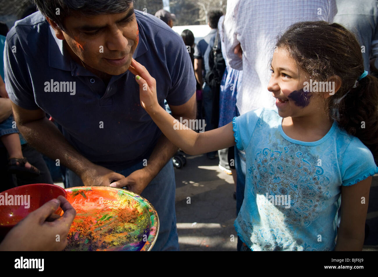 Polvere colorata viene applicata per i volti dei partecipanti come si celebra la vacanza indiano di Holi a street festival di NY Foto Stock