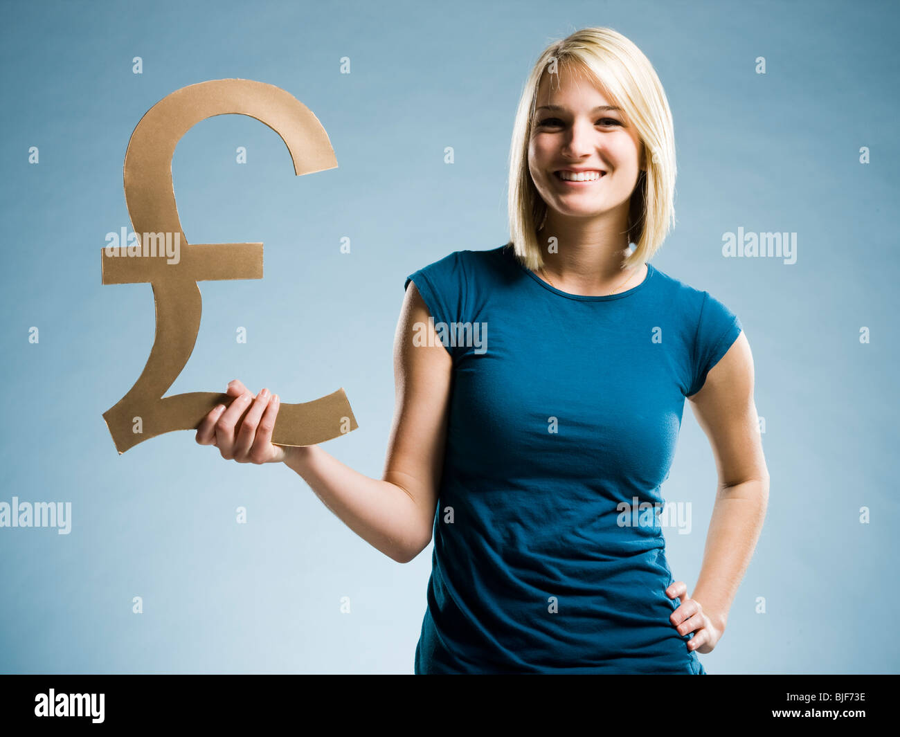 Donna che mantiene fino a British pound simbolo Foto Stock