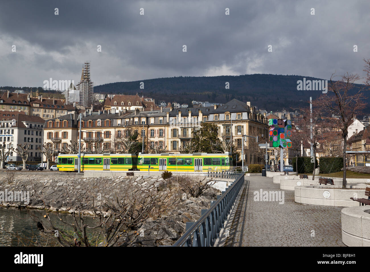 Un tram lungo il lungomare, con cityscape, Neuchatel, Svizzera. Charles Lupica Foto Stock