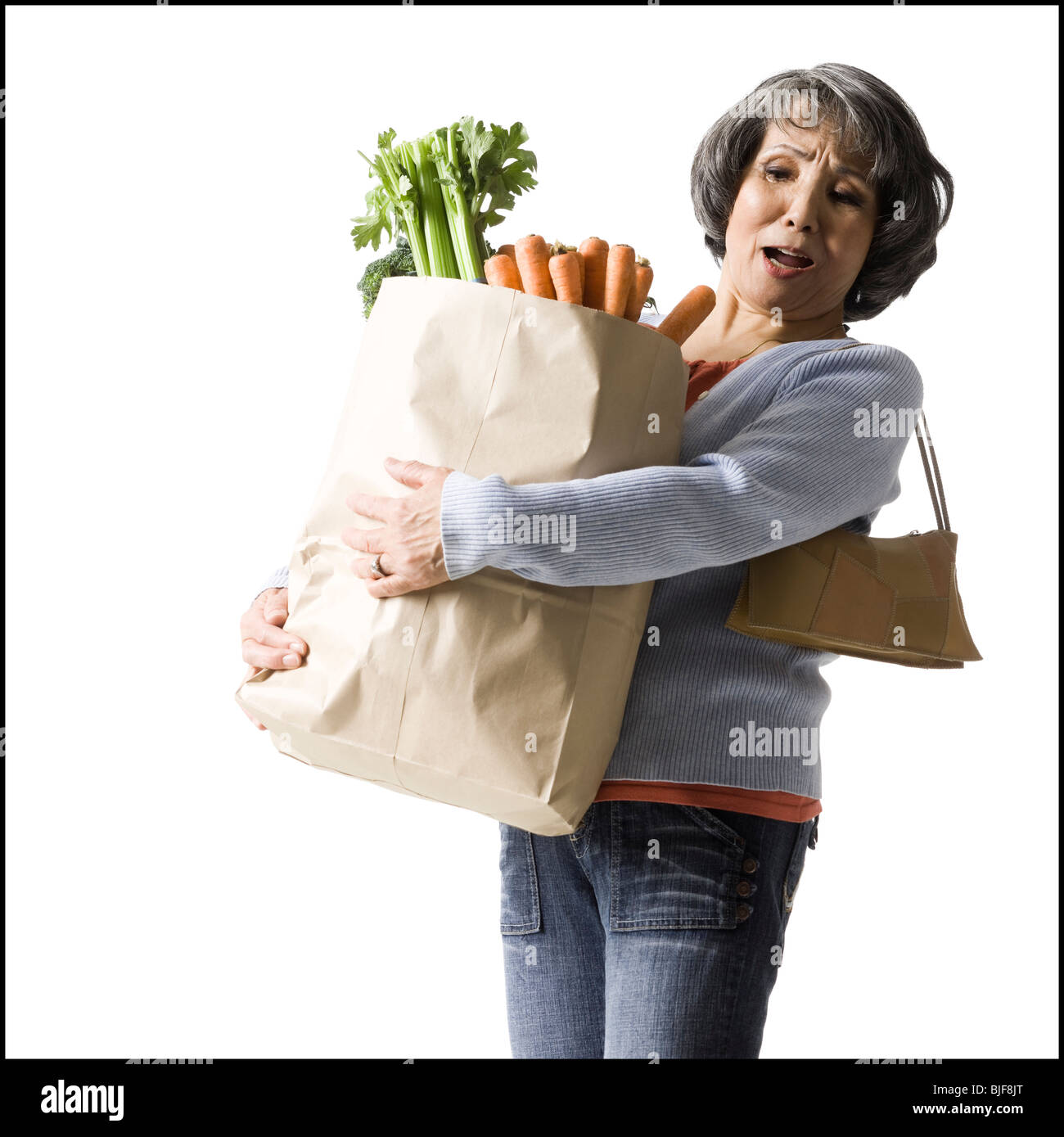Donna che mantiene un sacco di negozi di generi alimentari Foto Stock