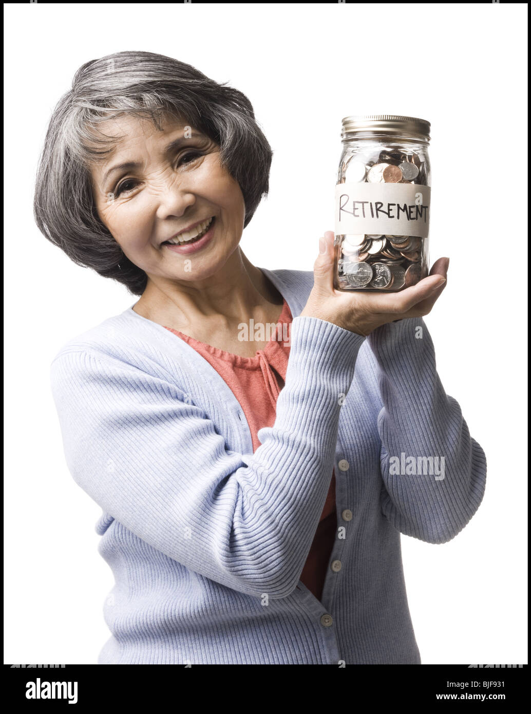 Una donna con un vaso pieno di monete Foto Stock