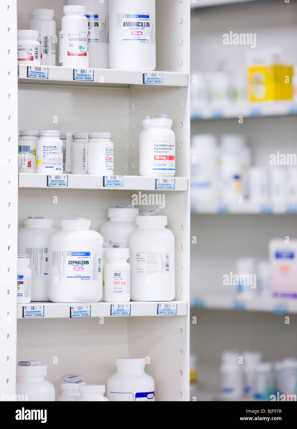 Bottiglie sugli scaffali in una farmacia Foto Stock