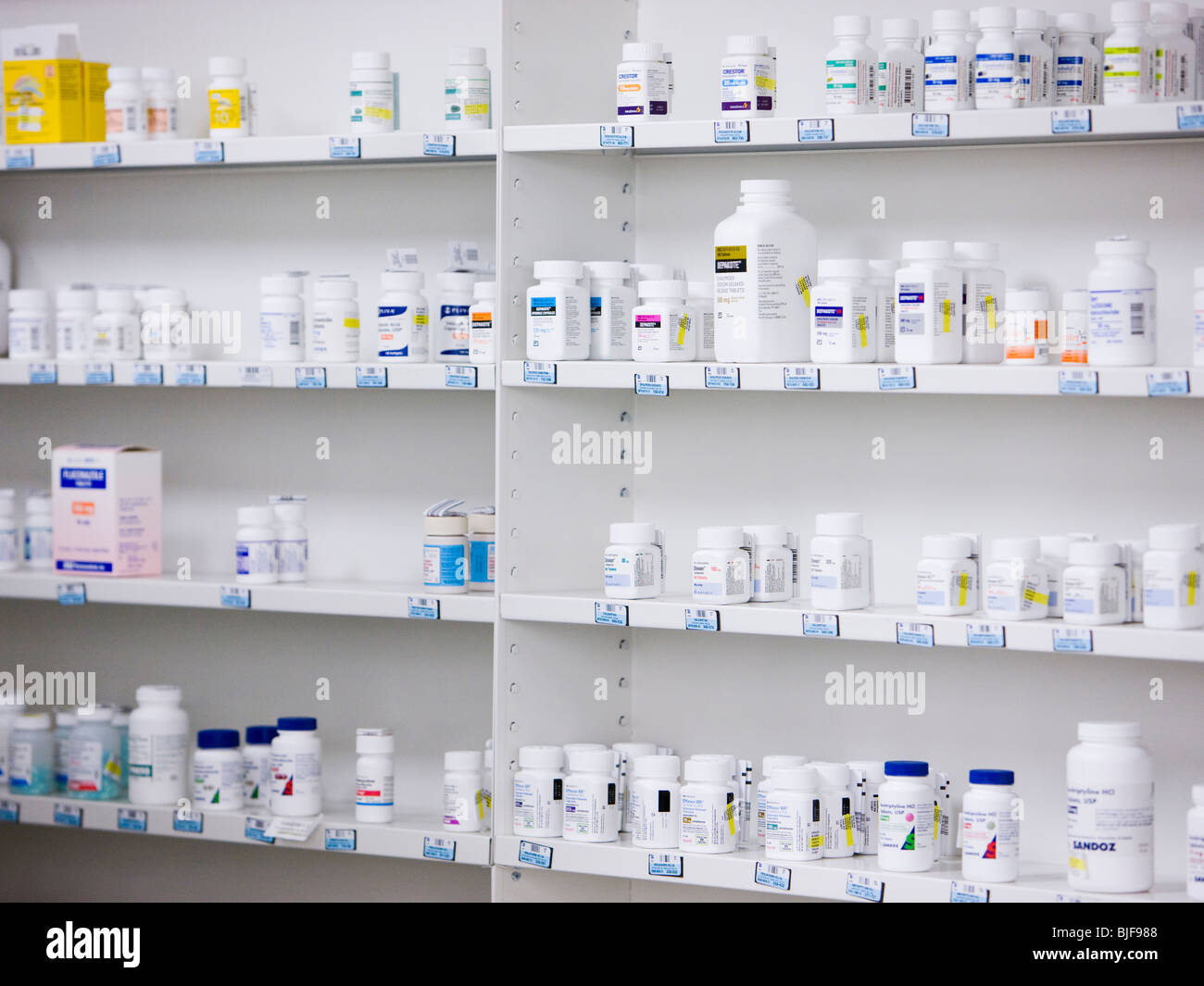 Bottiglie sugli scaffali in una farmacia Foto Stock