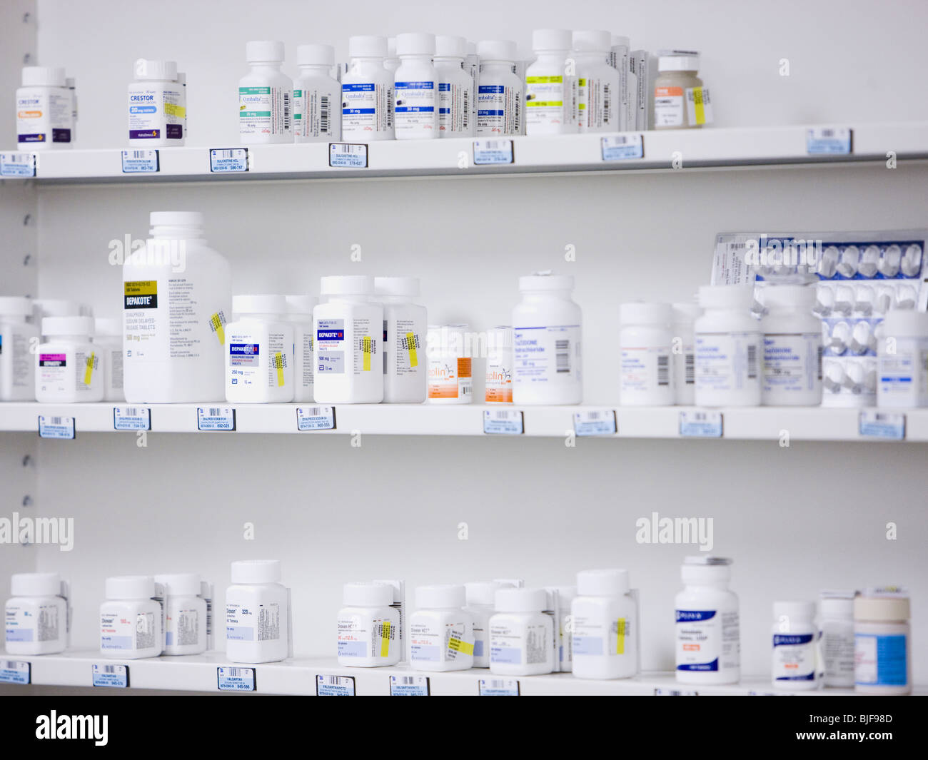 Bottiglie sugli scaffali in una farmacia Foto Stock
