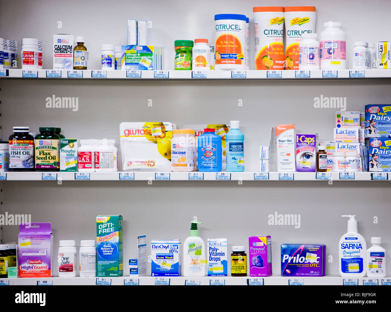 Bottiglie sugli scaffali in una farmacia Foto Stock