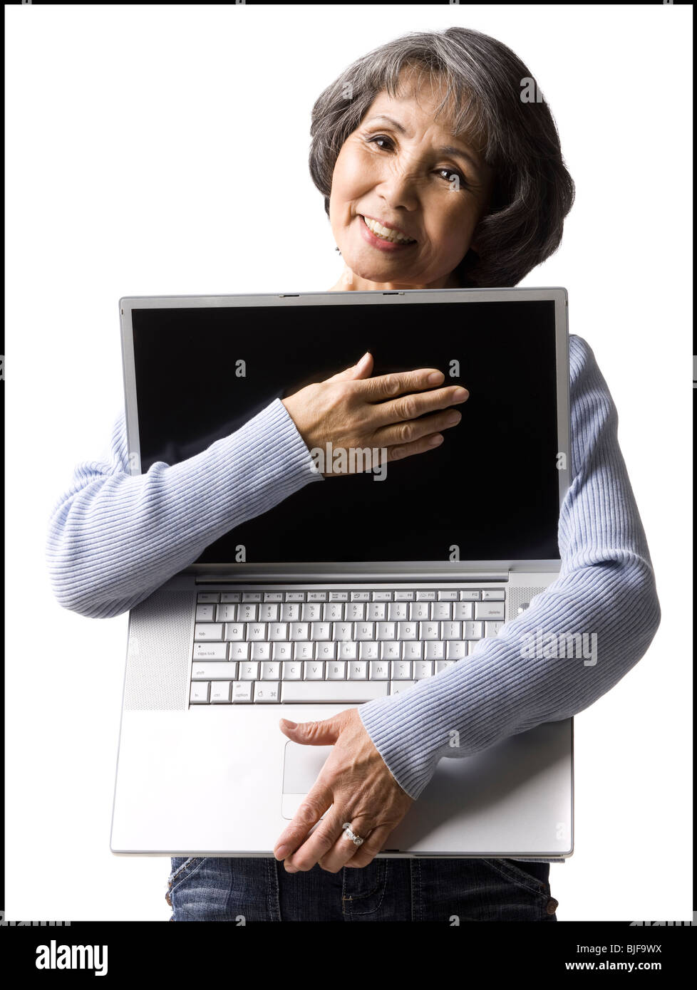 Senior donna che mantiene un notebook Foto Stock