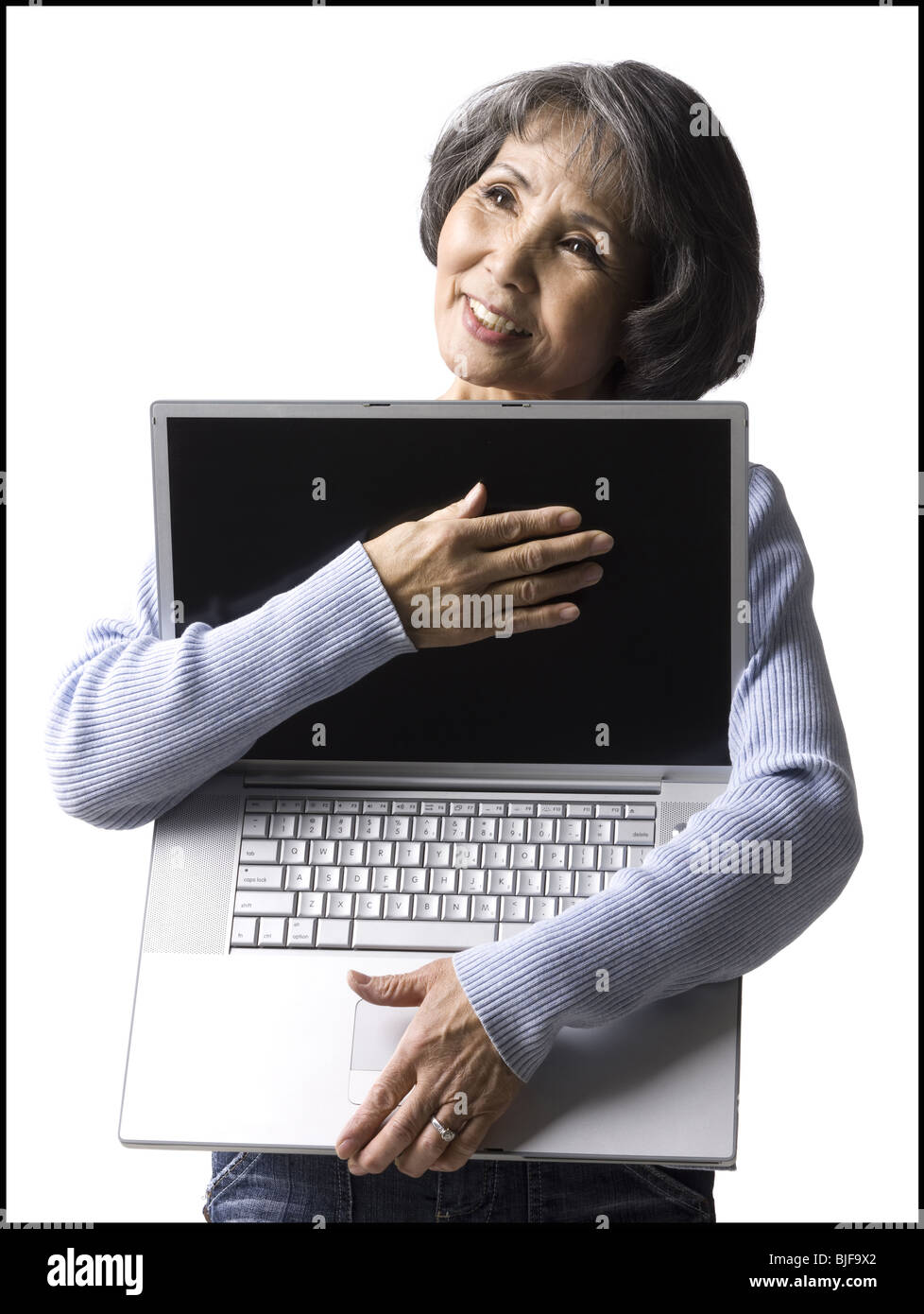 Senior donna che mantiene un notebook Foto Stock