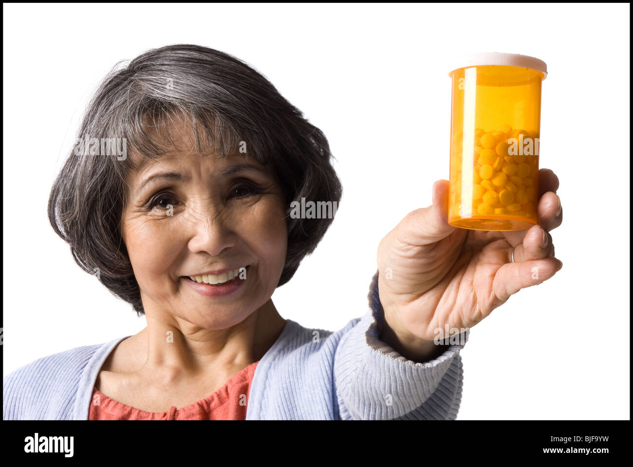 Senior donna tenendo una bottiglia di pillole Foto Stock