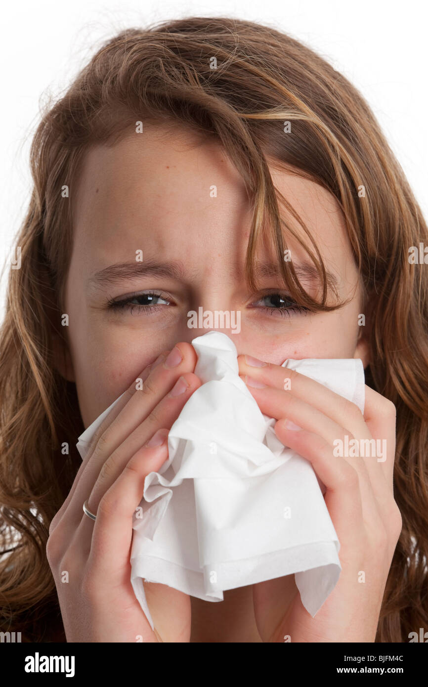 Ragazza adolescente soffia il naso in un fazzoletto di carta Foto Stock