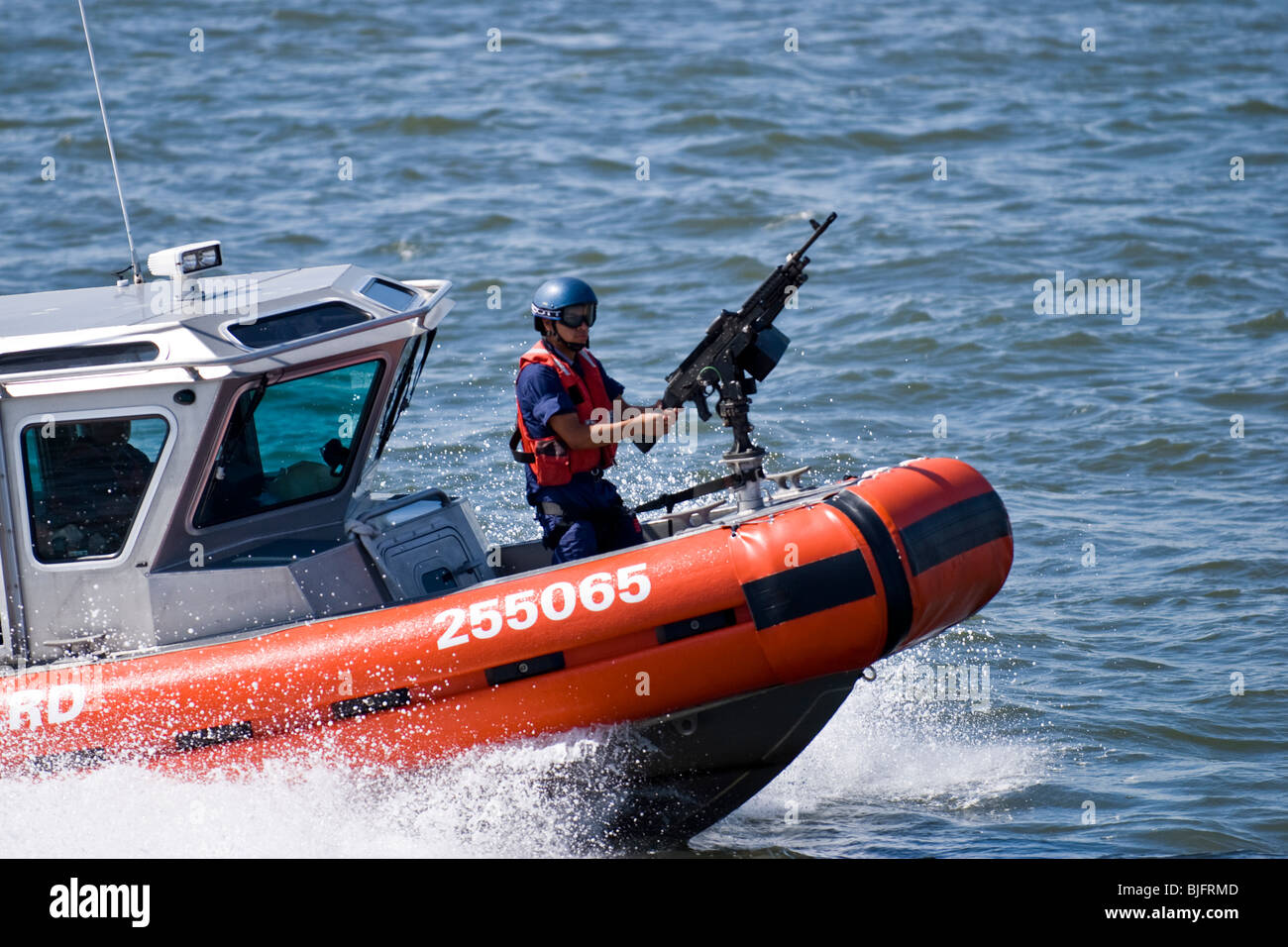 New York Coast Guard motoscafo sul fiume Hudson con Officer manning heavy machine gun Foto Stock