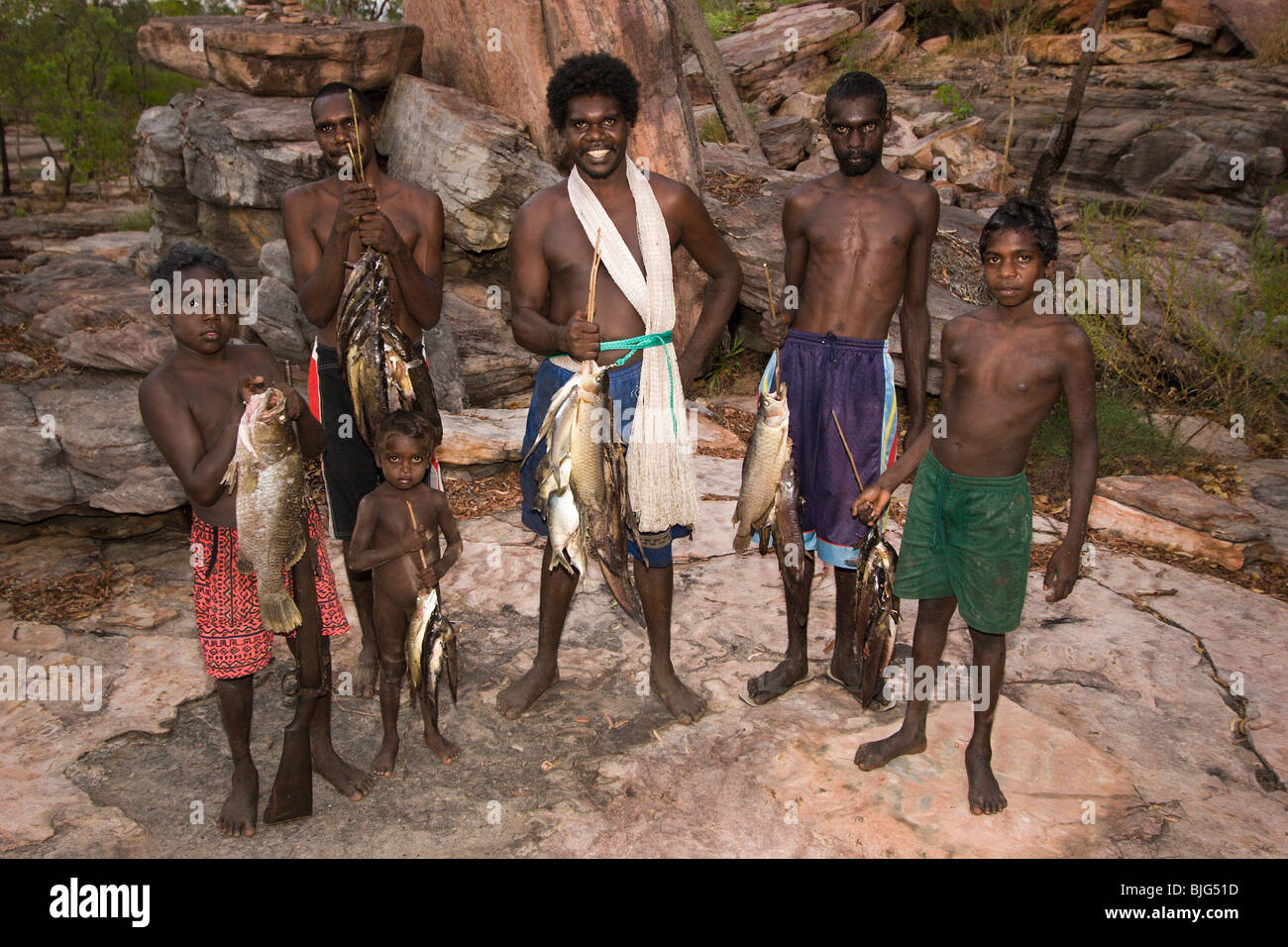 Aborigeno & ragazzi con molti pesci orgogliosamente ritorno dalla pesca il fiume Cadell nel loro paese clan a Dukaladjarrang. Foto Stock