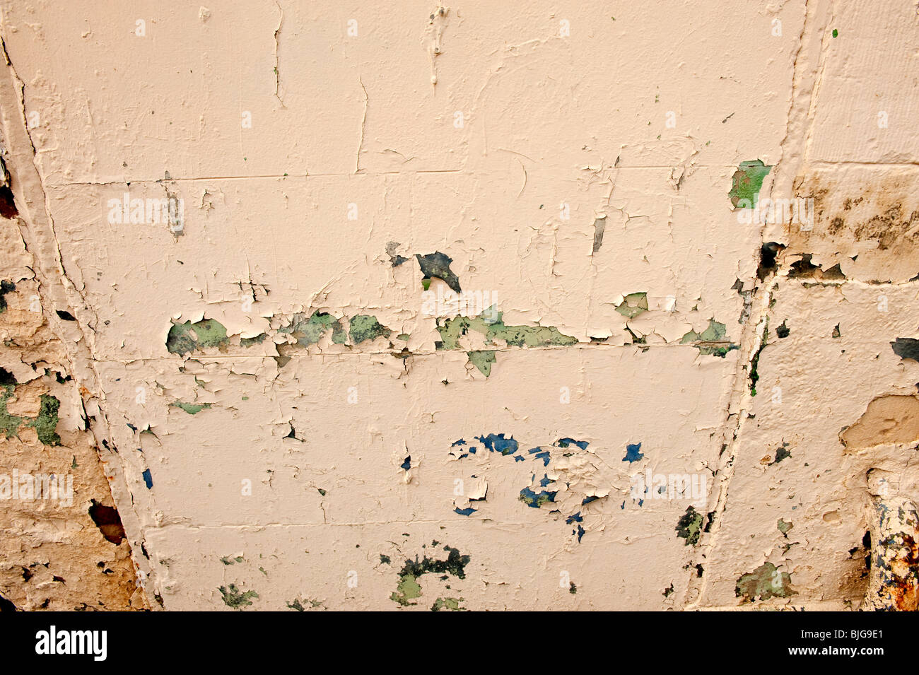 Lo sfaldamento vecchi strati di vernice sul muro di pietra Foto Stock