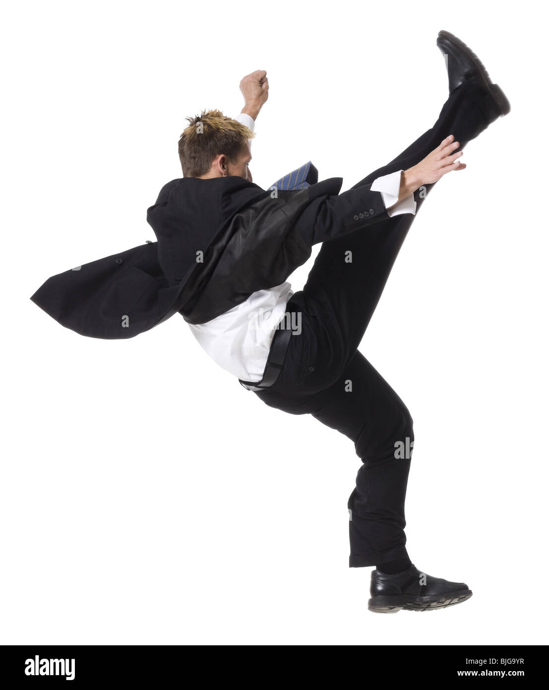 Imprenditore facendo un karate kick Foto Stock