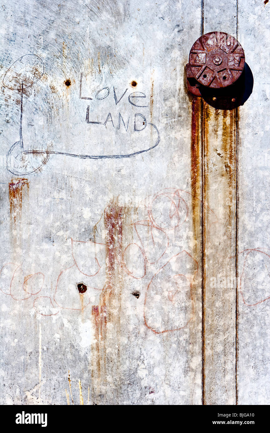 Metallo arrugginito che qualcuno ha scrawled 'amore terra' su in Guffey, Colorado. Foto Stock