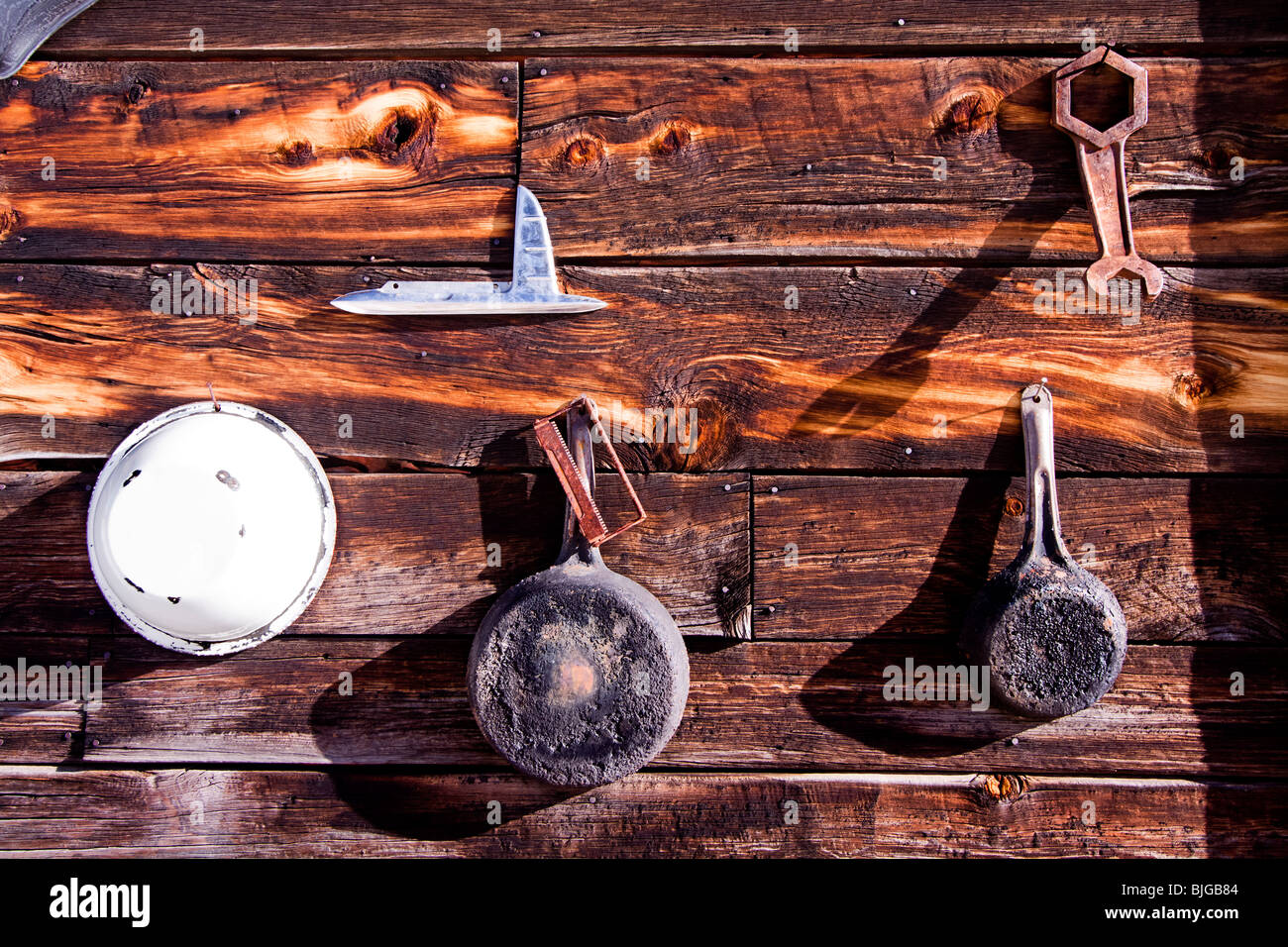 Pentole, padelle e attrezzi assortiti appendere alla parete esterna di una cabina di legno in Guffey, Colorado, Stati Uniti d'America. Foto Stock