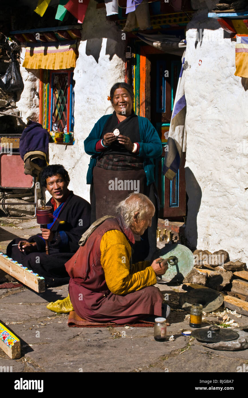 La gente del posto lavoro in un cortile in un tempio buddista nel villaggio di SAMAGAUN sul intorno il MANASLU TREK - REGIONE NUPRI, NEPAL Foto Stock