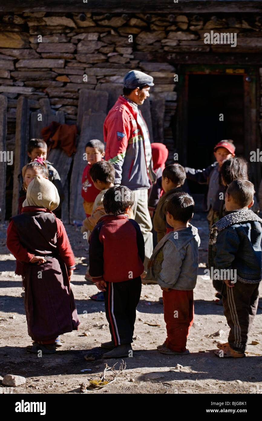 Maestro di scuola e i bambini nel villaggio di SAMAGAUN sul intorno il MANASLU TREK - REGIONE NUPRI, NEPAL Foto Stock