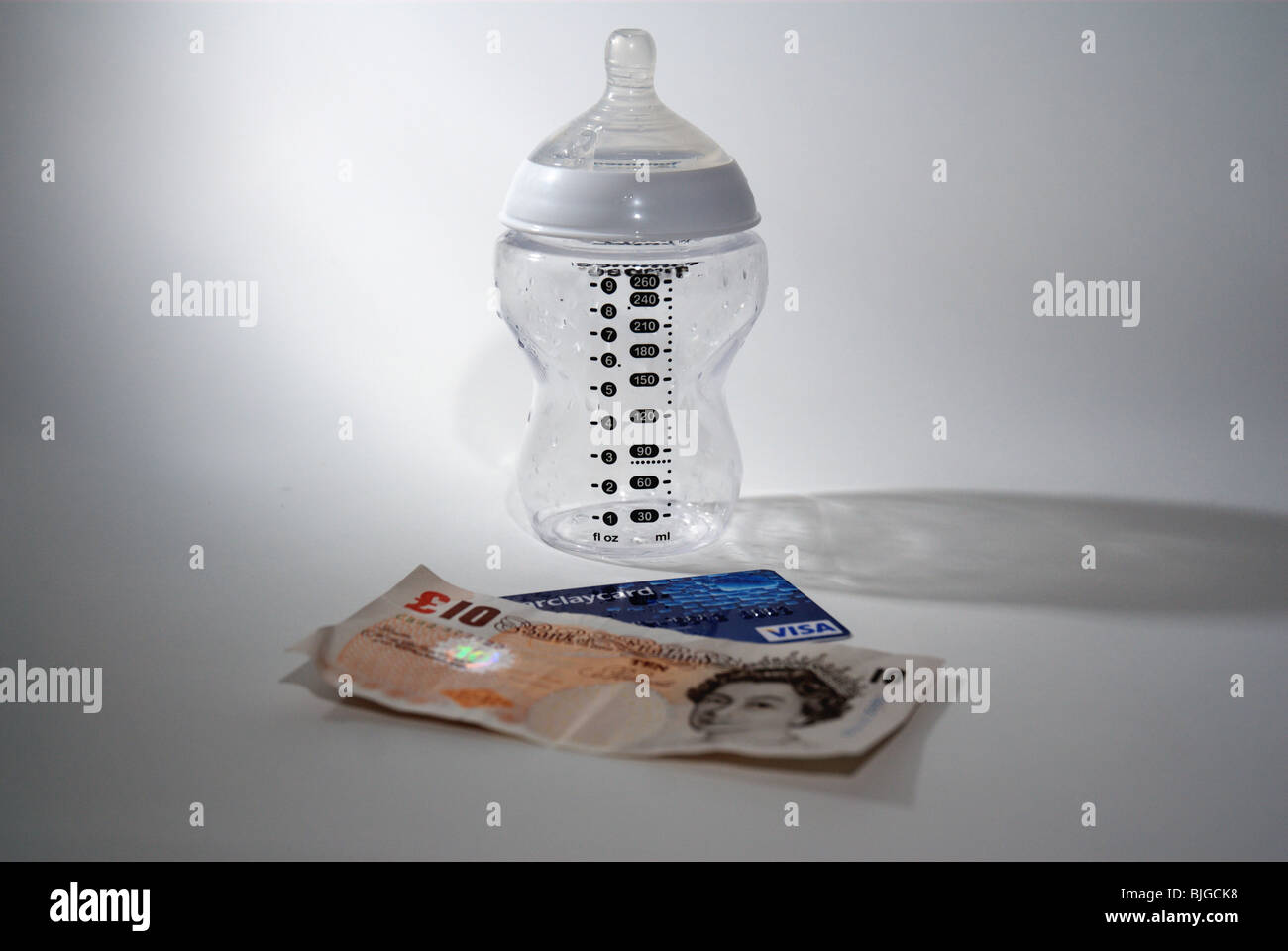 Biberon con carta di credito e di denaro nel Regno Unito per illustrare il costo di avere un bambino e i bambini Foto Stock