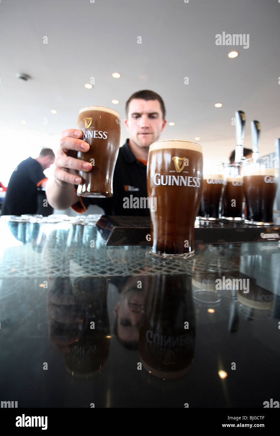 Uomo che serve birra Guinness, Dublino, Irlanda Foto Stock