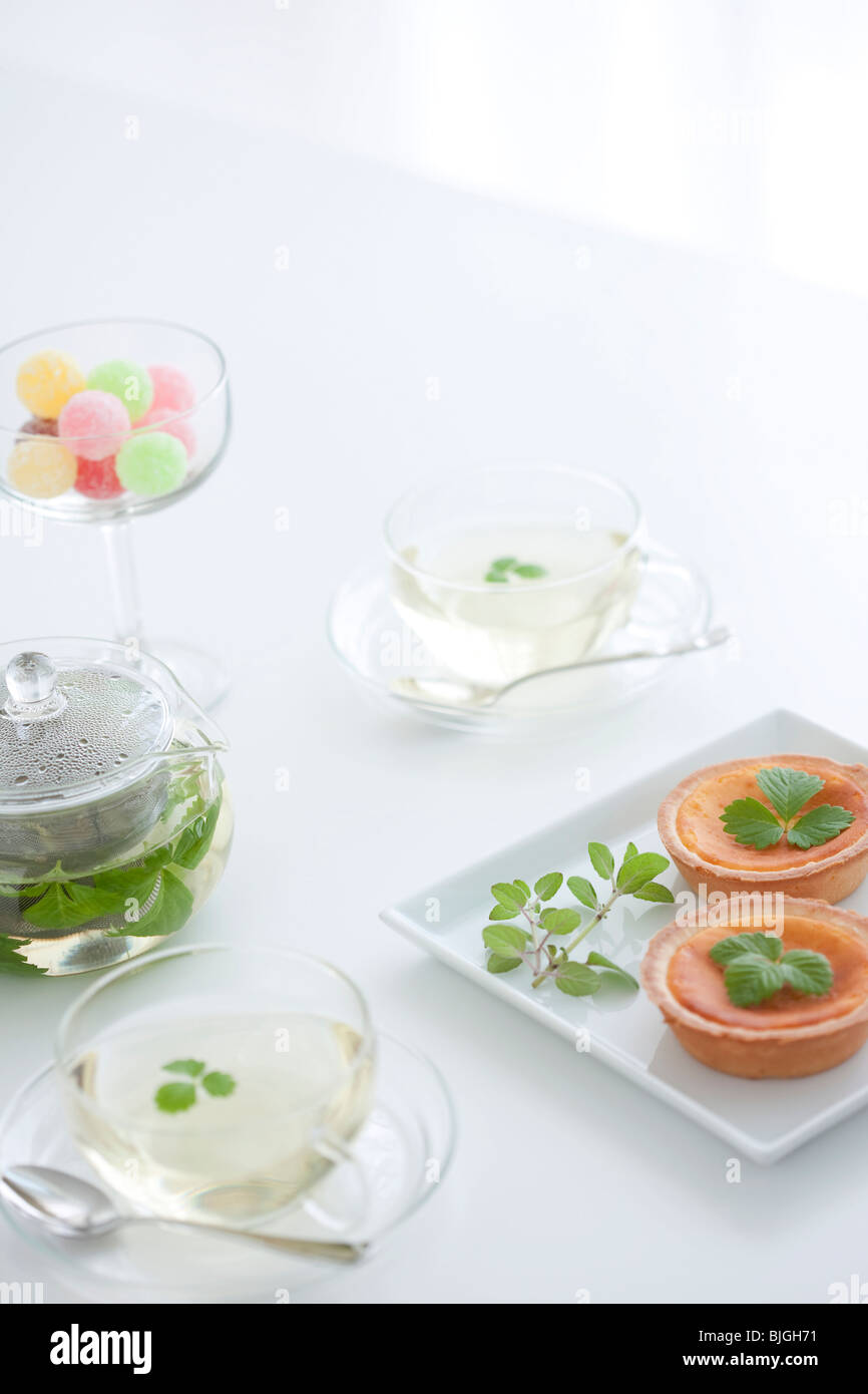 Il tè alle erbe, un bicchiere di Candy e crostate Foto Stock