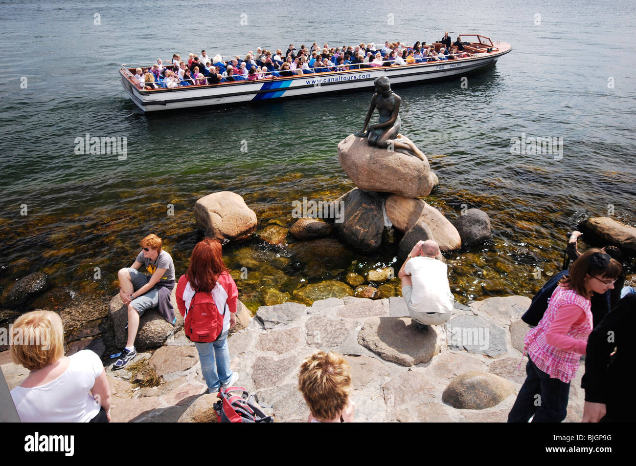 I turisti si riuniscono intorno a Copenaghen di attrazione turistica principale: la scultura in bronzo Den lille havfrue, La Sirenetta. Foto Stock