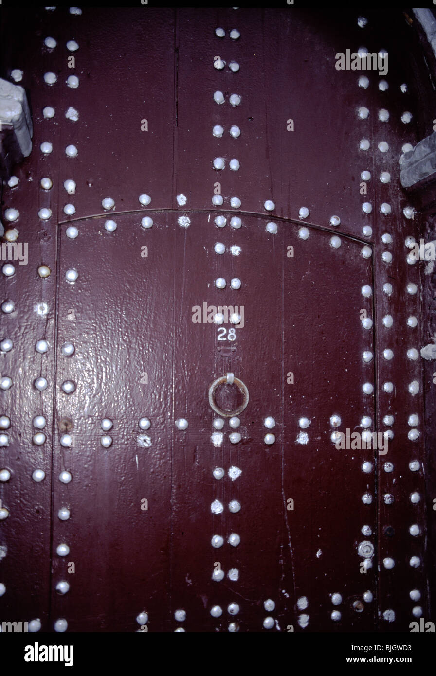 Antica porta in legno e decorate con metallo lucido prigionieri, Rabat il Marocco. Piccolo ingresso con chiave di foro e la maniglia in metallo della cabina può essere visto. Foto Stock