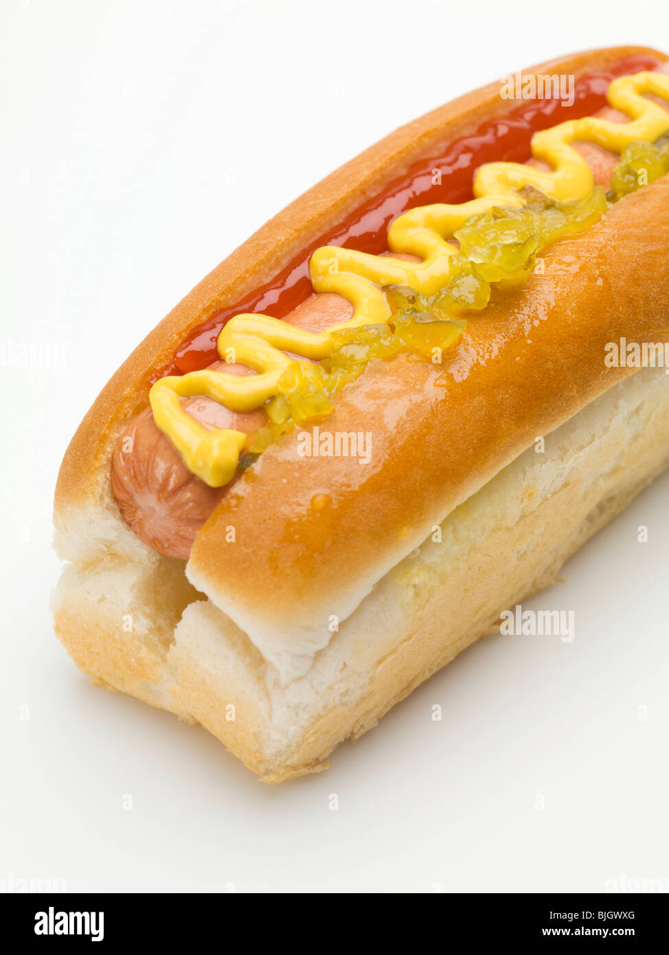 Un hot dog con senape e ketchup e cetriolino - Foto Stock