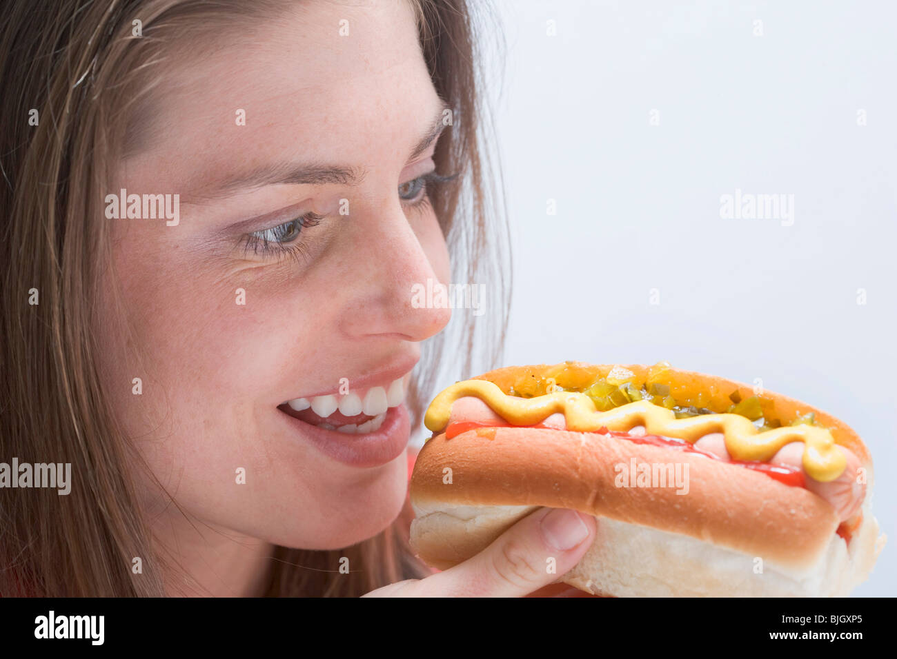 Giovane donna guardando un hot dog - Foto Stock