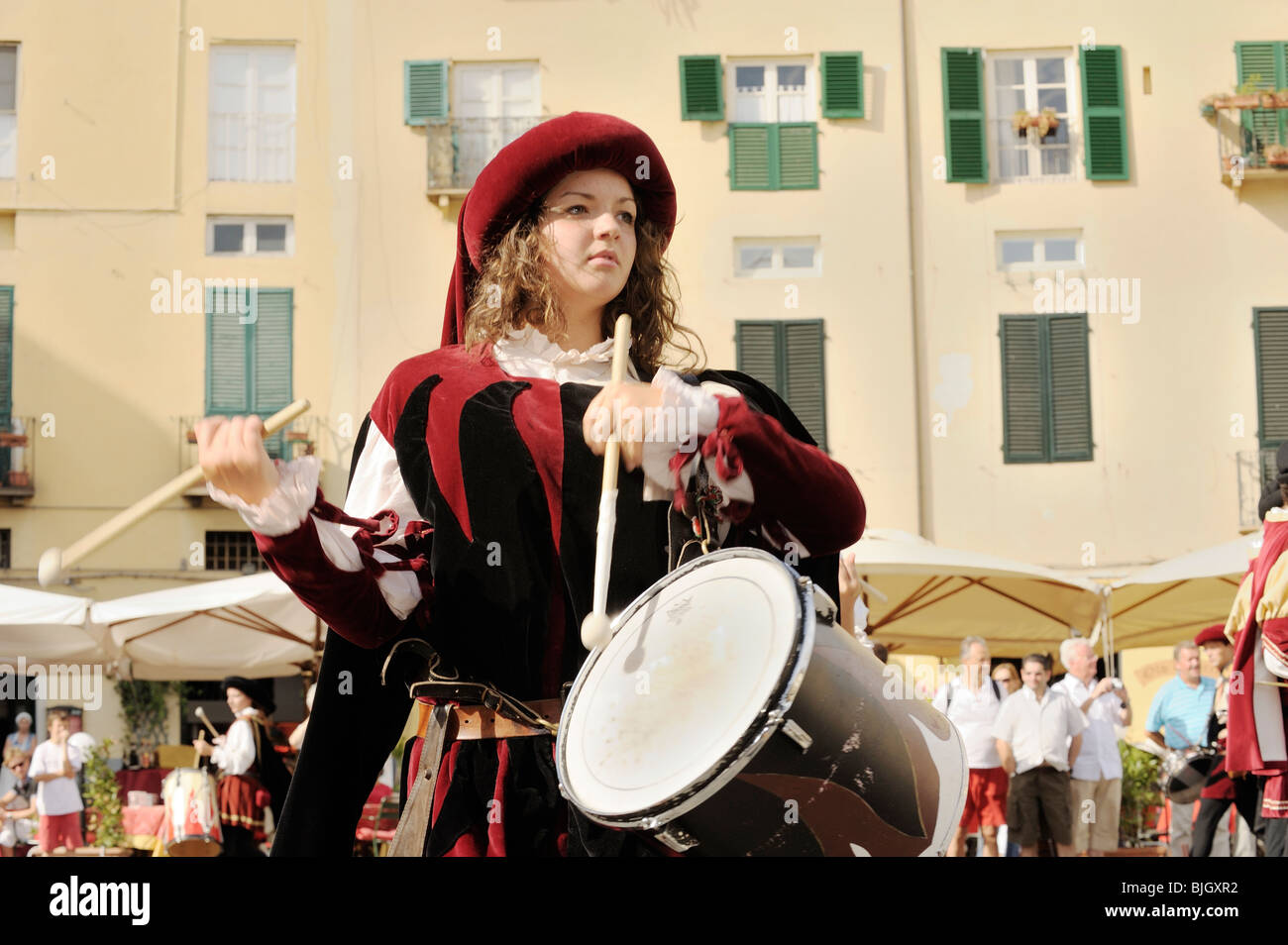 Città italiana di Lucca. I giovani locali batterista donna in costume medievale street pageant festival. Toscana, Italia Foto Stock