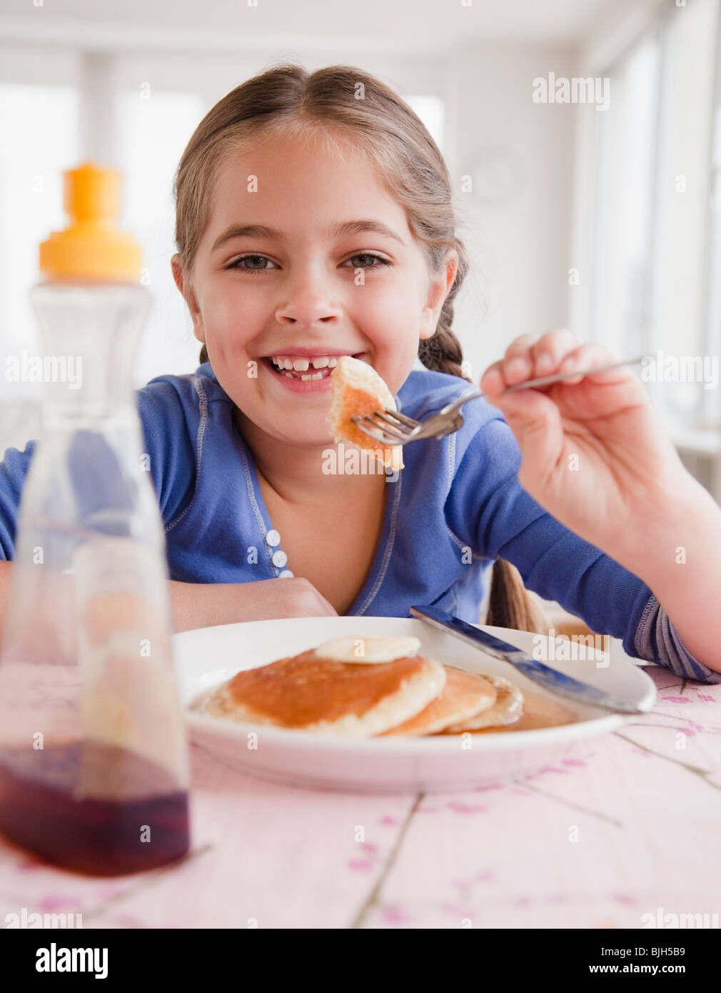 Ragazza giovane mangiare pancake Foto Stock