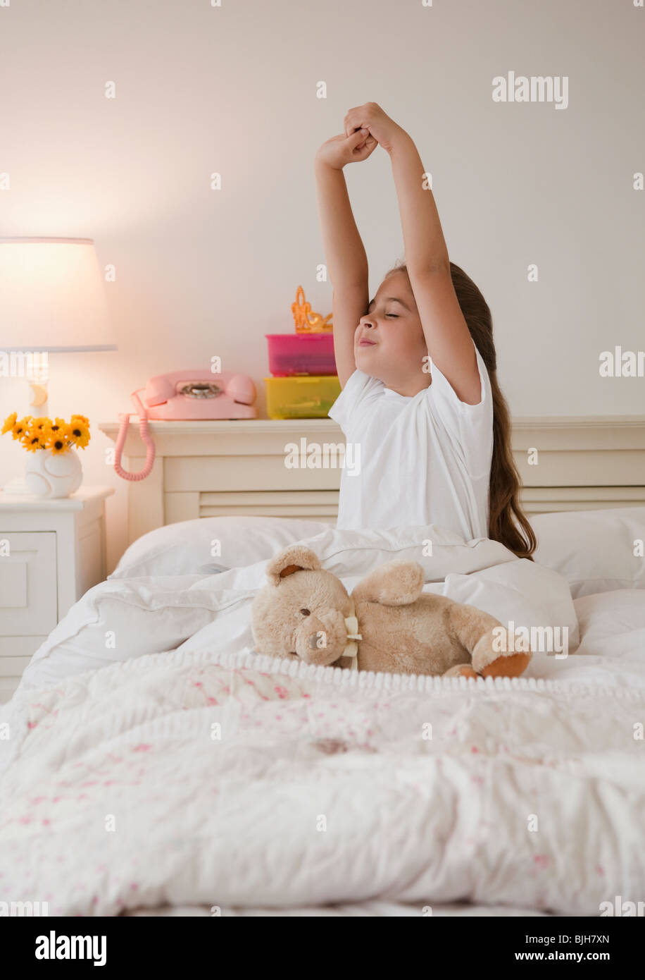 Ragazza giovane stretching nel letto Foto Stock