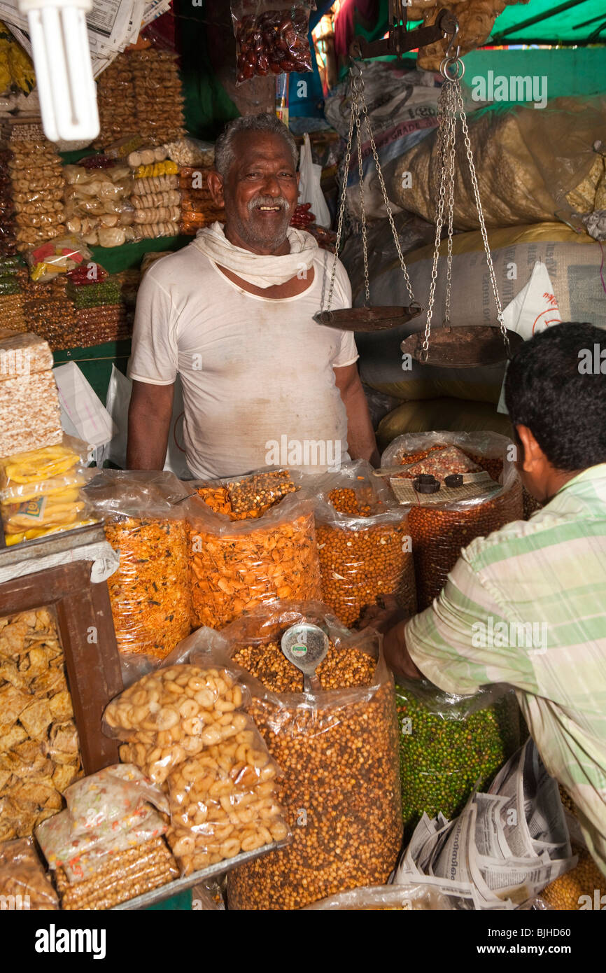 India Kerala, Kanjiramattom Kodikuthu festival musulmano, snack in stallo uomo dietro di sacchi di snack croccante Foto Stock