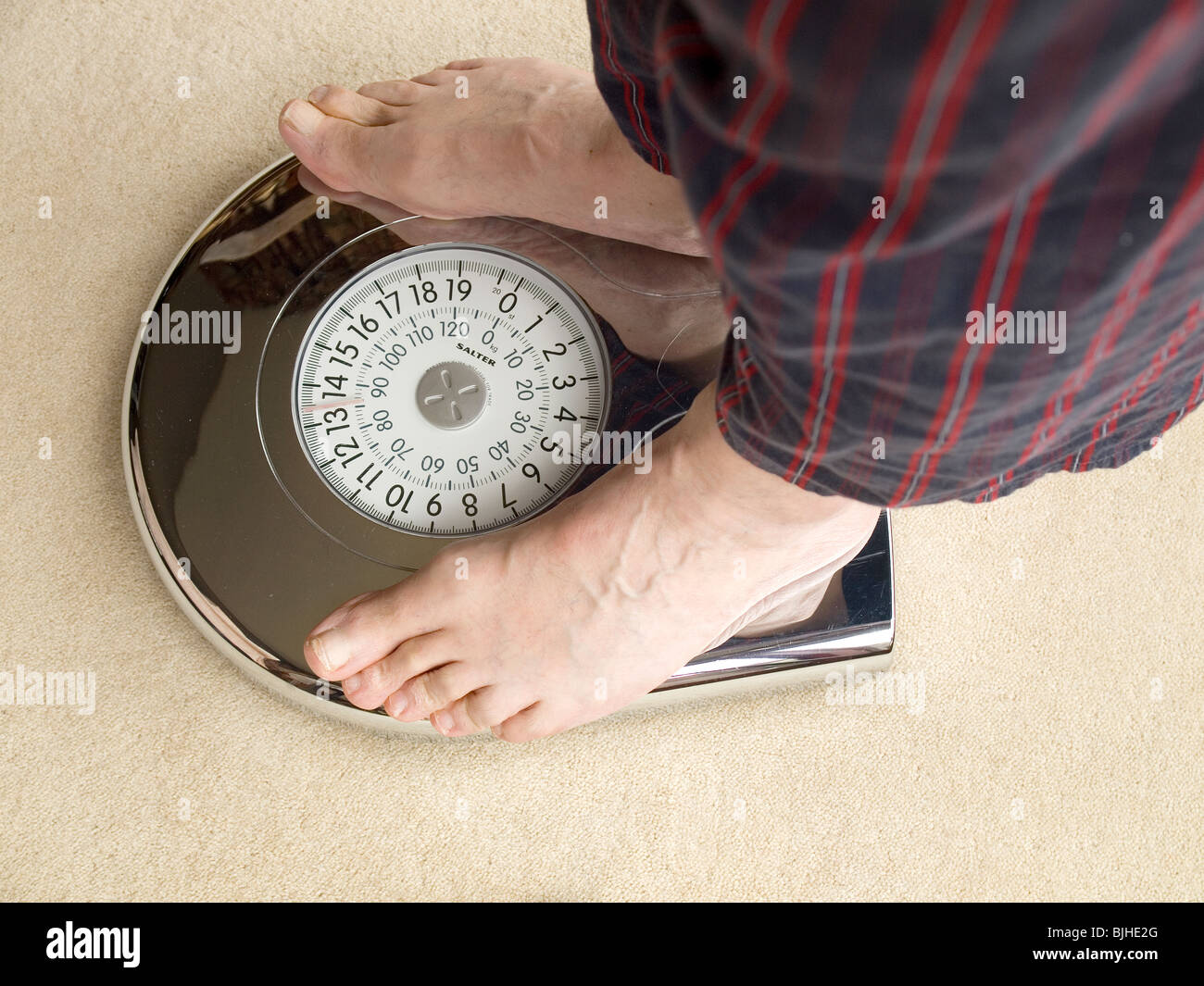 I piedi di un attenta alla salute uomo in piedi sulla bilancia da bagno Foto Stock