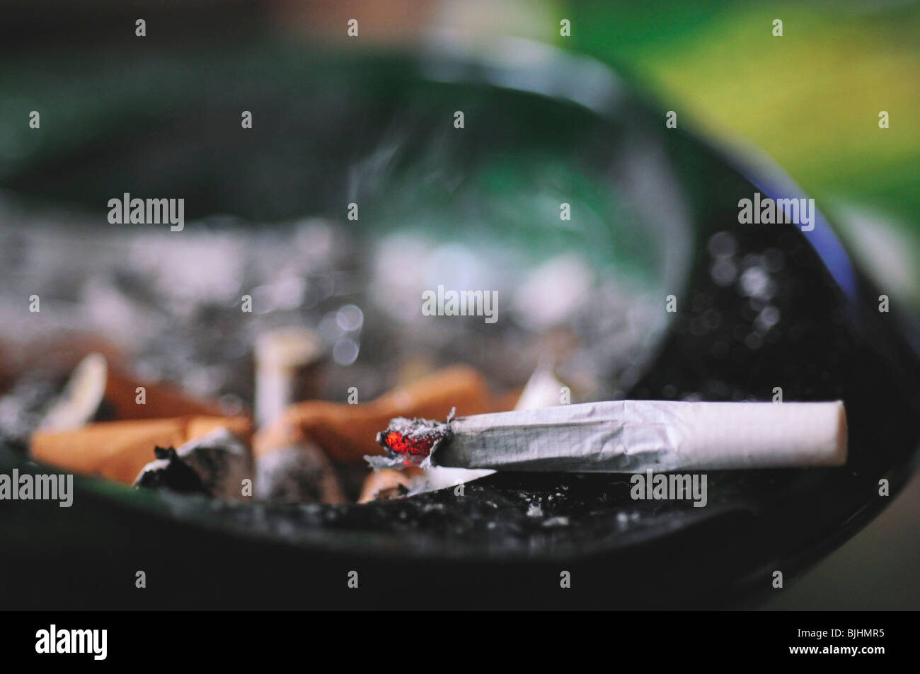 Chiusura del rotolo di sigaretta in un portacenere Foto Stock