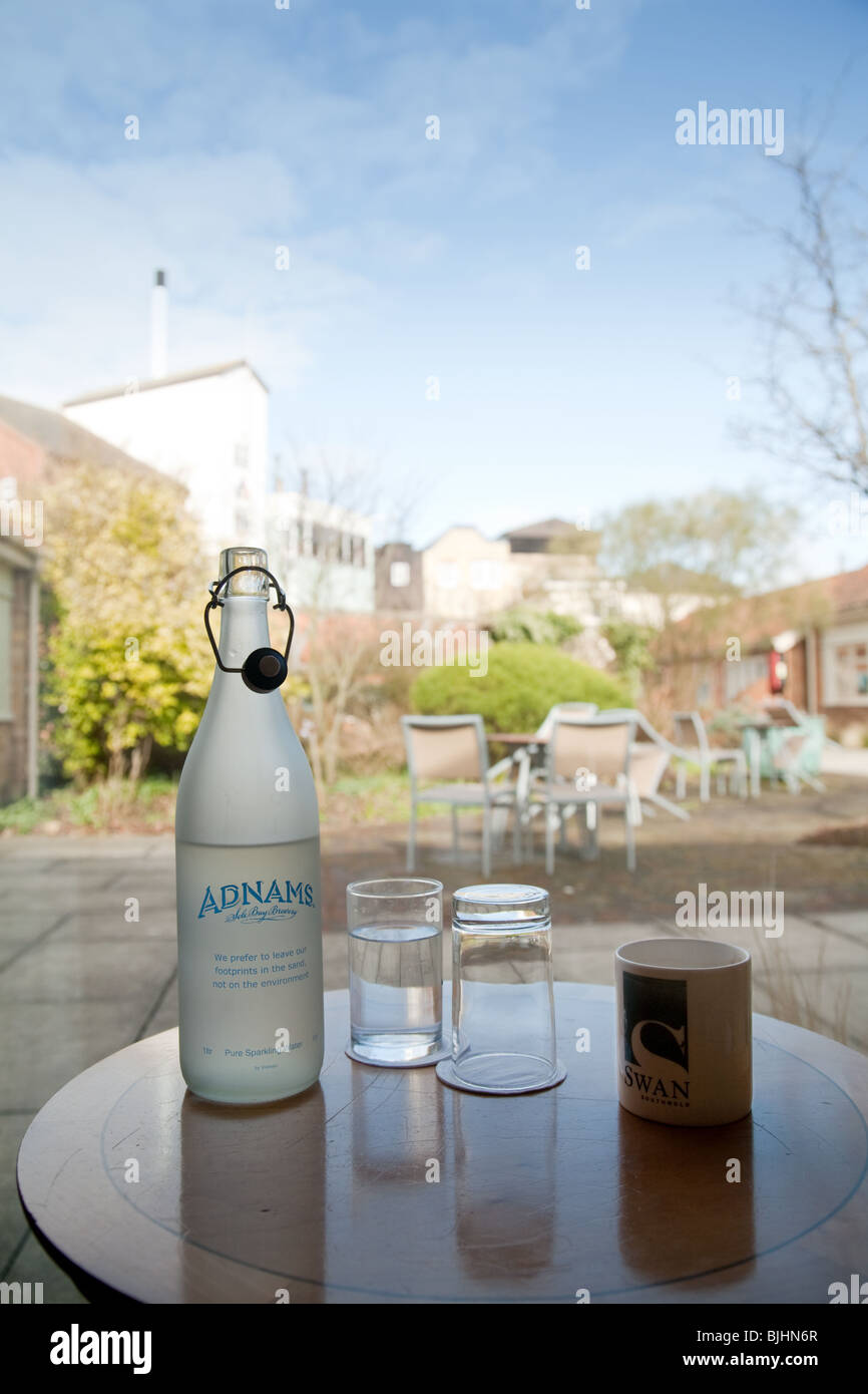 Una bottiglia di Adnams acqua minerale in camera in the Swan Hotel, Adnams brewery in background; Southwold, Suffolk, Regno Unito Foto Stock