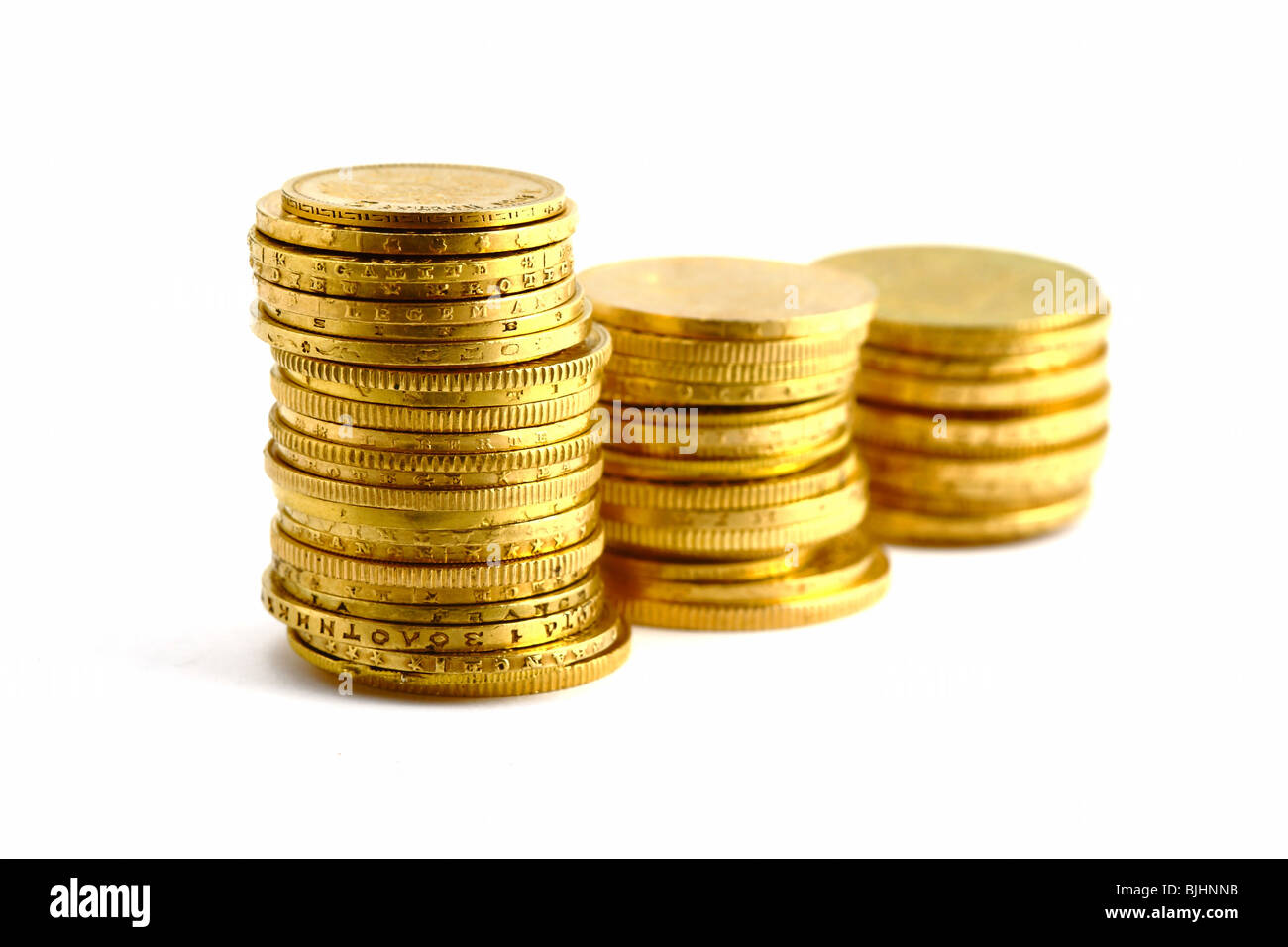 Le monete d'oro su sfondo bianco Foto Stock