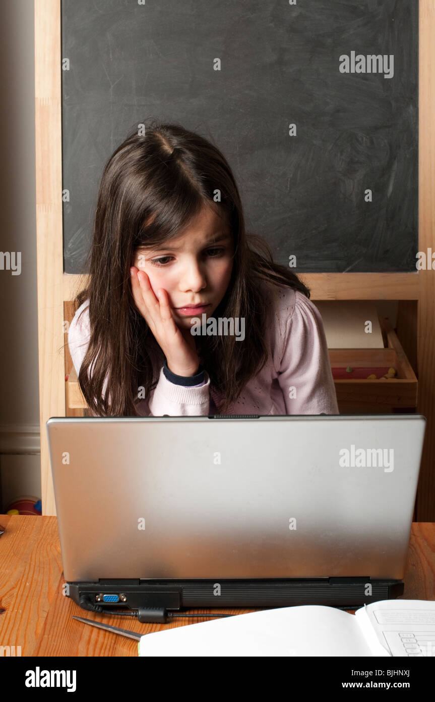 Schoolgirl su un portatile a casa Foto Stock