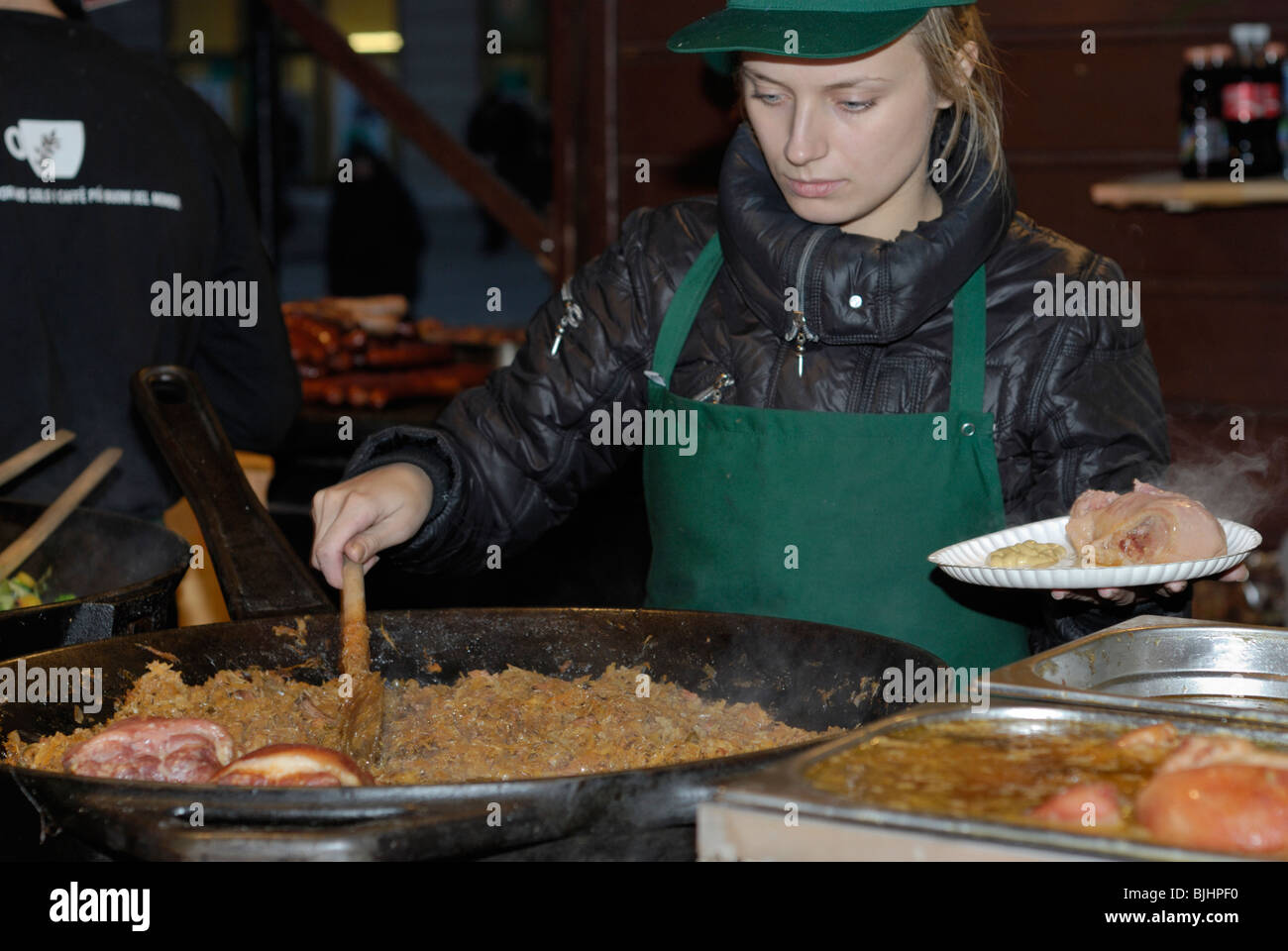 Servire i crauti e carne di maiale il fuso a snodo, Cracovia mercatino di Natale, Polonia Foto Stock