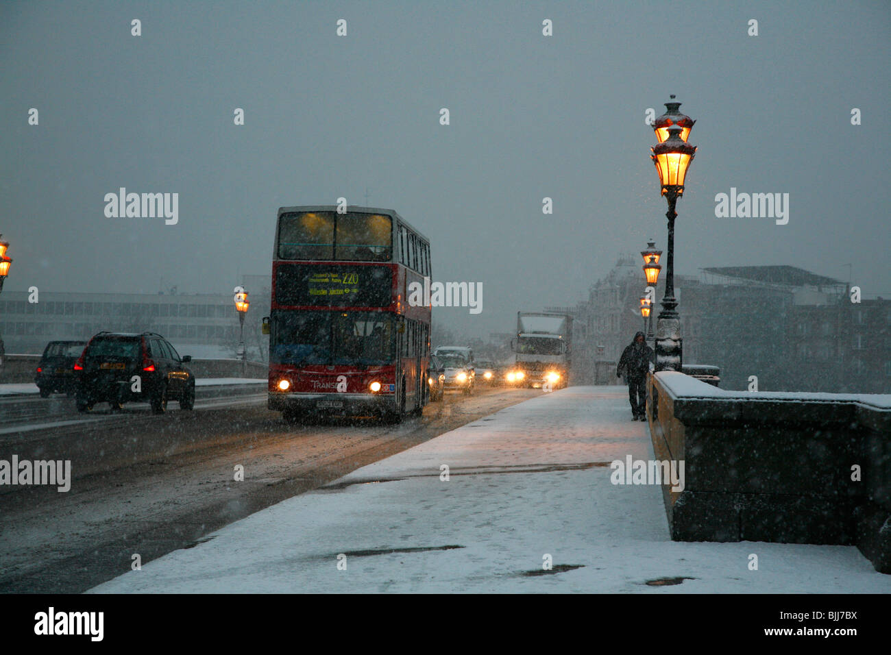 Il traffico che attraversa una snowbound Putney Bridge, Fulham, Londra, Regno Unito Foto Stock
