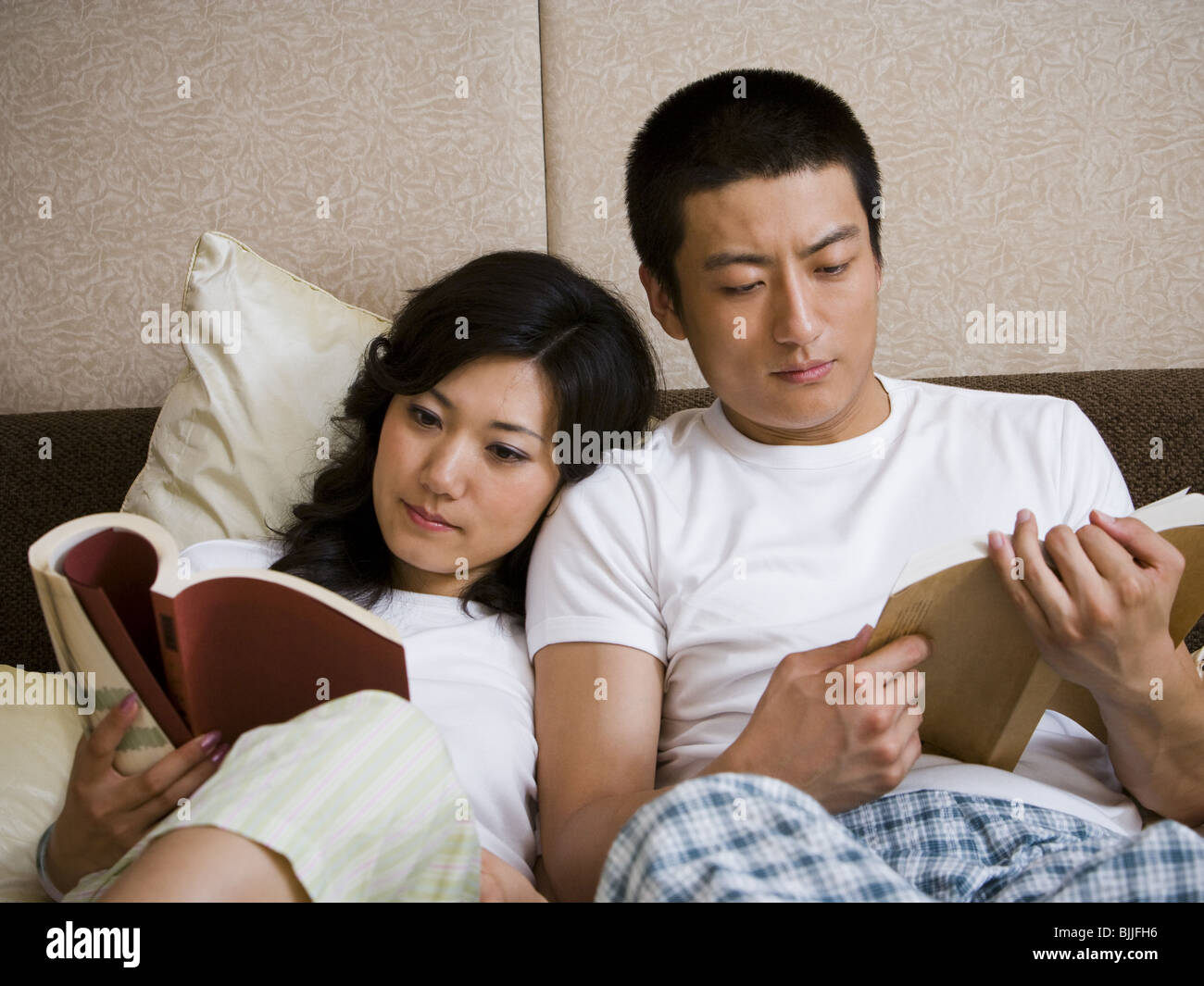 Matura nel letto snuggling e la lettura Foto Stock