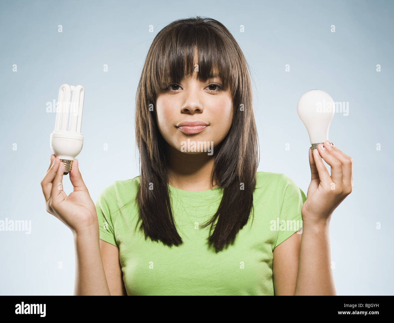 Donna con lampade fluorescenti e lampade ad incandescenza Foto Stock