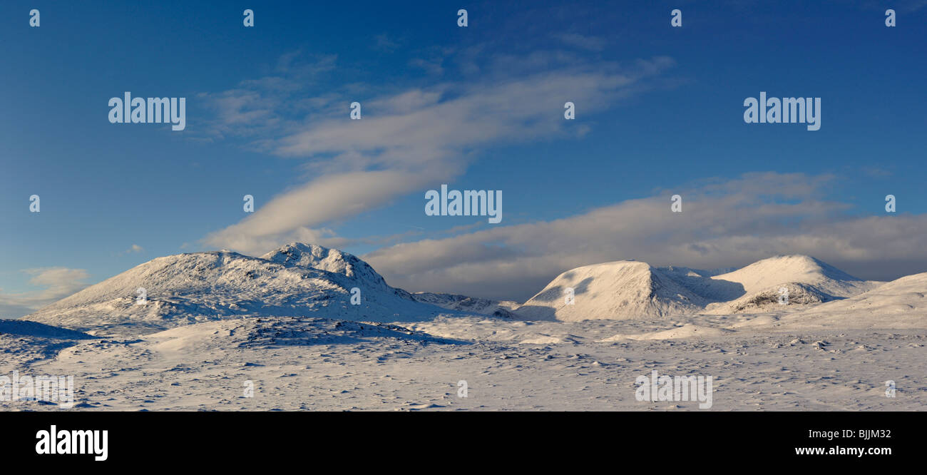 Panorama di lontane montagne innevate e cielo blu che si vede attraverso una vasta distesa di profondamente coperta di neve la brughiera e deviati neve Foto Stock