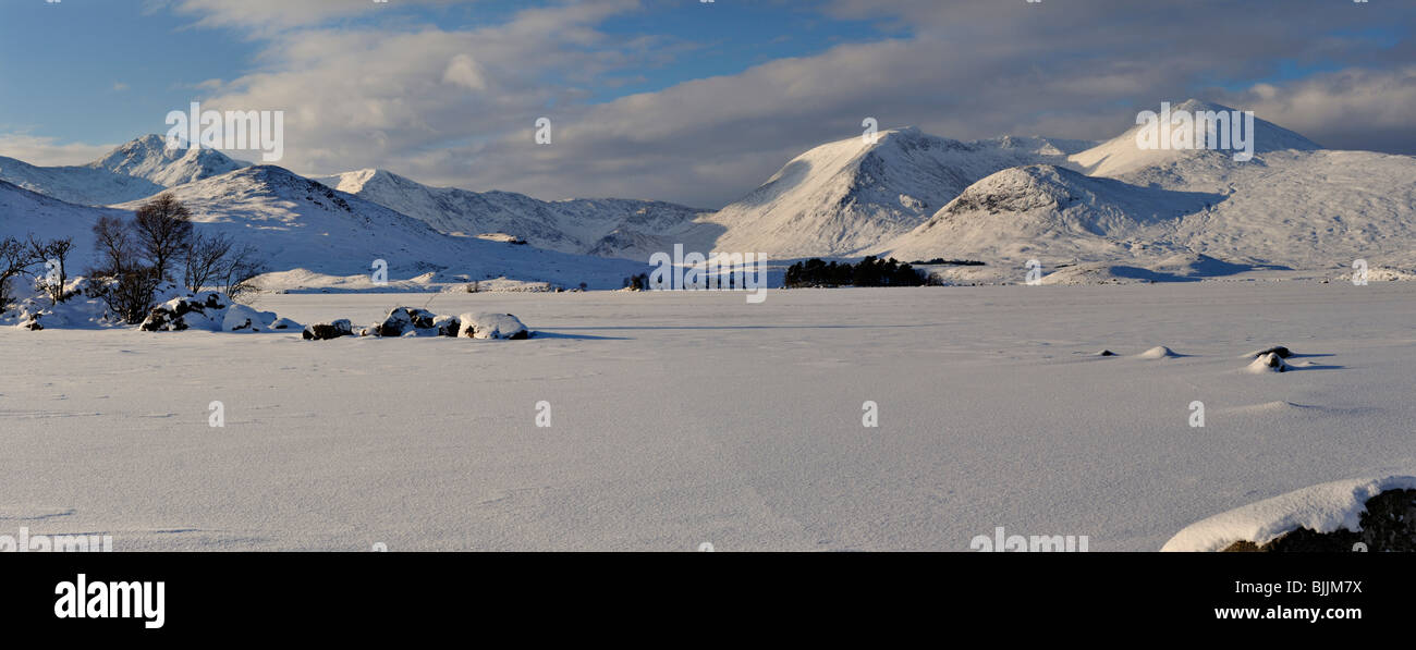 Panorama di lontane montagne innevate e cielo blu che si vede attraverso una vasta distesa di neve-coperta lago ghiacciato Foto Stock