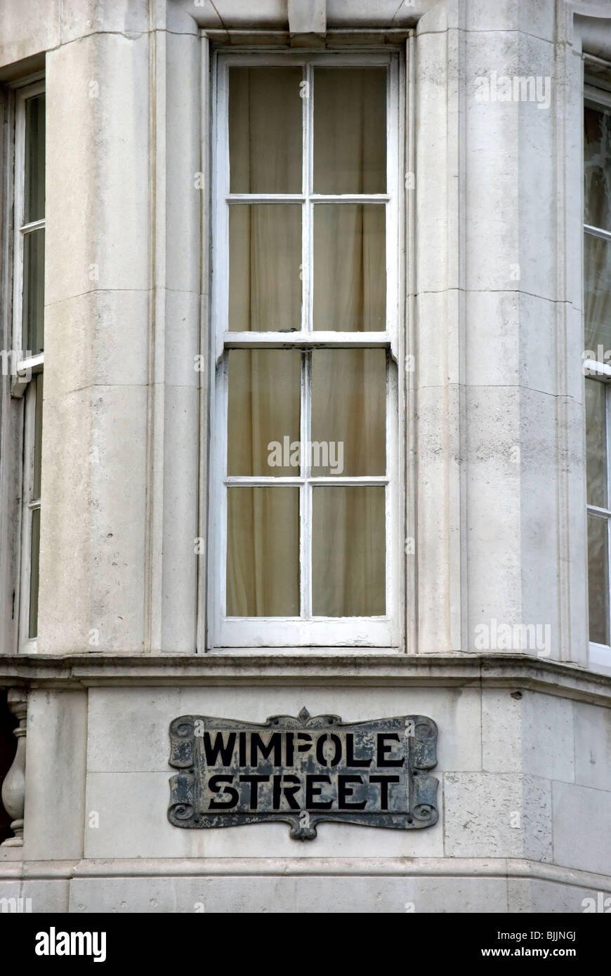 Nome strreet segno per Wimpole Street, Londra, Inghilterra, al di sotto di una finestra Foto Stock